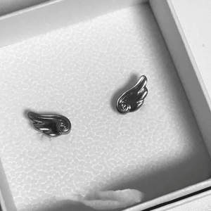 Silver wing-shaped earrings in a box