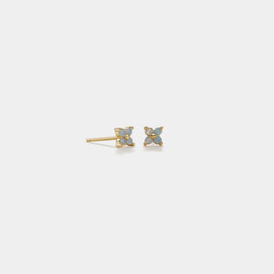 Pair of gold butterfly earrings with blue gemstones on a light gray background