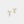 Pair of gold bow-shaped earrings with clear gemstones on a light gray background