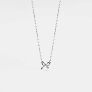 A small bow-shaped pendant necklace with a gold plating on a silver chain, presented against a white background.