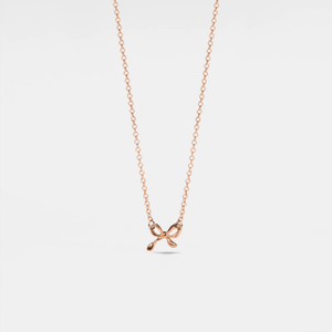 A small bow-shaped pendant necklace with a gold plating on a silver chain, presented against a white background.