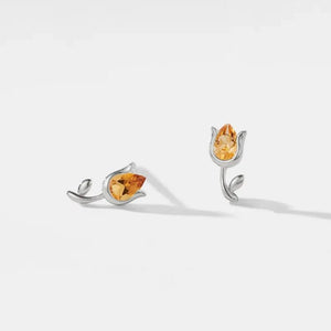 Pair of silver earrings with yellow gemstones on a white background
