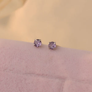 A collection of small, solid 925 sterling silver stud earrings with various colors of cubic zirconia displayed on a light background.