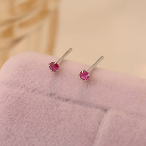 A collection of small, solid 925 sterling silver stud earrings with various colors of cubic zirconia displayed on a light background.