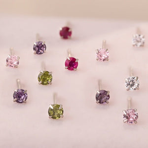 Collection of gemstone earrings on a display stand with a soft focus background.