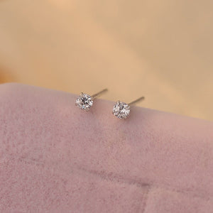 A collection of small, solid 925 sterling silver stud earrings with various colors of cubic zirconia displayed on a light background.