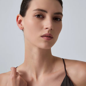 Close-up of a woman wearing a black top against a light gray background