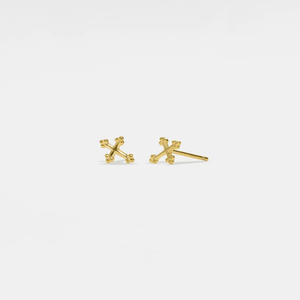 Gold cross-shaped earrings on a light gray background