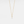 Gold necklace with a small cross pendant on a light gray background