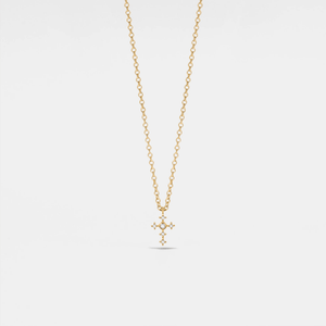 Gold necklace with a small cross pendant on a light gray background