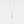 Gold cross necklace on a light gray background