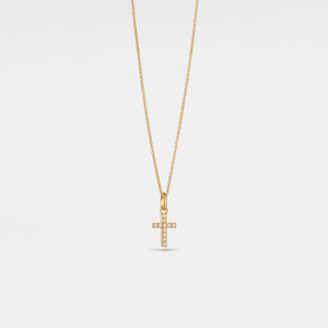 Gold cross necklace on a light gray background