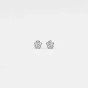 Pair of silver flower-shaped earrings on a light gray background