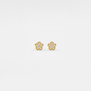 Gold flower-shaped earrings with clear gemstones on a light gray background