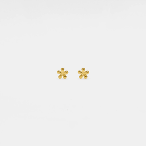 Pair of gold flower-shaped earrings on a light gray background