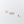 Gold and rose gold flower-shaped earrings on a light gray background