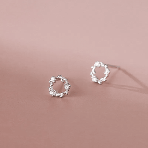 Silver earrings on a pink background