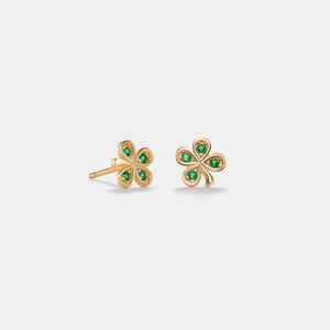 Gold four-leaf clover earrings with green gemstones on a light gray background