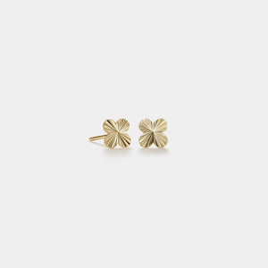 Gold earrings on a light gray background