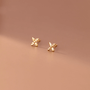 Gold earrings on a brown background