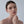 Woman with a neutral expression against a plain background