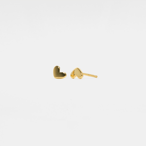 Gold heart-shaped earrings on a light gray background