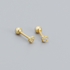Gold heart-shaped earrings with small diamonds on a gray background