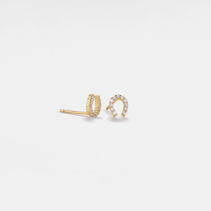 Gold earrings with small diamonds on a light gray background