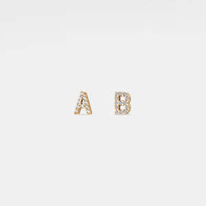 Gold earrings with 'A' and 'B' on a light gray background