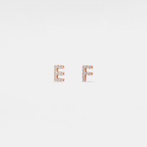 Rose gold 'E' and 'F' earrings on a light gray background