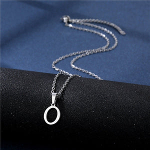 Silver necklace with a circular pendant on a black and blue fabric background