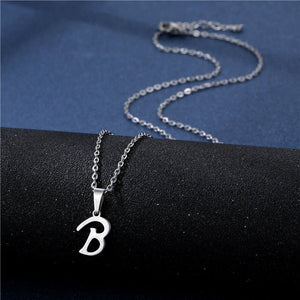 Silver necklace with a 'B' pendant on a black surface
