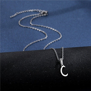 Silver necklace with a crescent moon pendant on a black and blue background