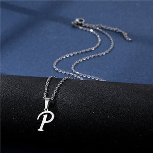 Silver necklace with a 'P' pendant on a black and blue fabric background