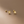 Gold leaf earrings on a beige background
