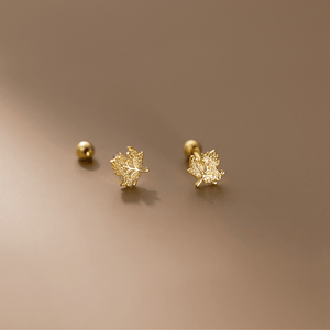 Gold leaf earrings on a beige background