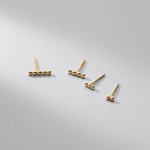 Set of gold earrings on a light gray background