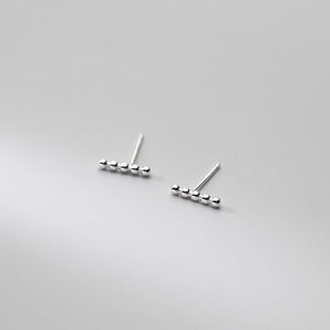 Pair of silver bar earrings on a light gray background