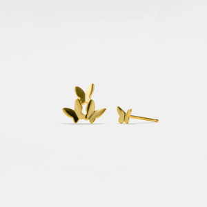 Gold leaf-shaped earrings on a light gray background
