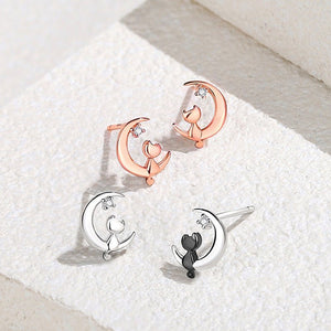 Pair of cat-shaped earrings on a textured white surface