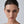 Close-up of a woman's face with a neutral expression on a gray background