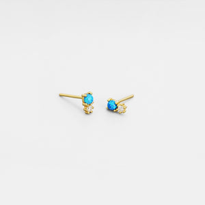 Gold earrings with blue gemstones on a white background