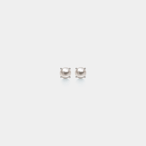 A pair of dainty pearl stud earrings with gold plating on a white background.