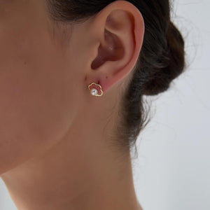 Close-up of an ear wearing a pearl earring with a blurred background
