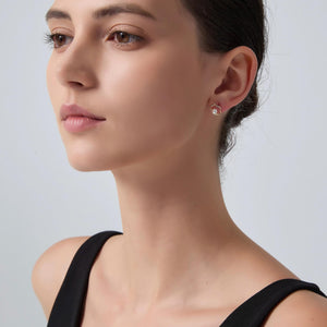 Close-up of a woman wearing a diamond earring against a light gray background