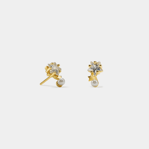 Gold earrings with pearls and clear stones on a white background