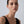 Woman wearing a black sleeveless top against a plain background