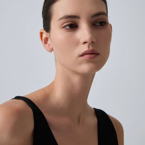 Woman wearing a black sleeveless top against a plain background