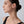 Woman wearing a small earring on a plain background
