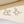 Silver bow-shaped earrings on a beige background